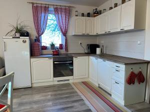 a kitchen with white cabinets and a stove top oven at Chalupa u lesa in Žlebské Chvalovice +16 photos