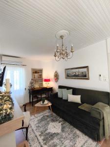 un soggiorno con divano nero e pianoforte di Elia House 2 near Nafpaktos a Lóngos