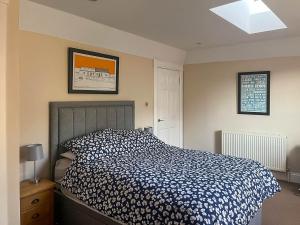 een slaapkamer met een bed met een blauw en wit dekbed bij 2 The Langhouse in Inverkip