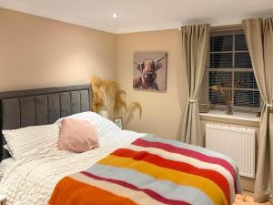 een slaapkamer met een bed met een kleurrijke deken erop bij 2 The Langhouse in Inverkip