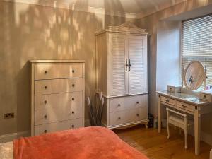een slaapkamer met een dressoir, een bed en een bureau bij 2 The Langhouse in Inverkip +3 foto's