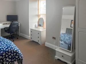 een slaapkamer met een bed, een bureau en een spiegel bij 2 The Langhouse in Inverkip