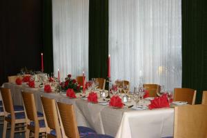 a long table with red napkins and candles on it at Hotel Krone in Bad Münster am Stein-Ebernburg