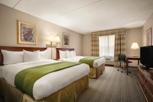 夏洛特的住宿－夏洛特大學江山旅館與套房酒店，酒店客房设有两张床和电视。