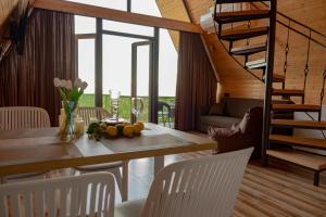 a dining room with a table and chairs and a staircase at Aurarest - აურარესთ in Makho