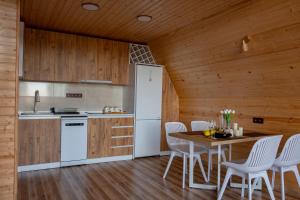 a kitchen with wooden walls and a table and chairs at Aurarest - აურარესთ in Makho +21 photos