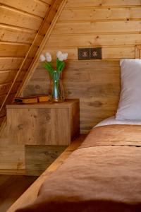 a bedroom with a vase with flowers in it at Aurarest - აურარესთ in Makho