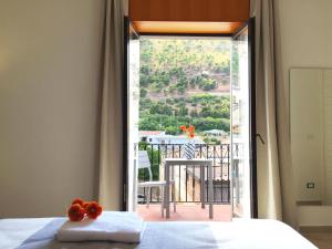1 dormitorio con cama y vistas a un balcón en Corso Ventinove, en Castellammare del Golfo