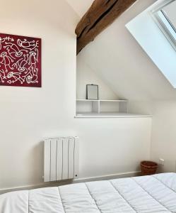 a bedroom with a white bed and a window at La Cachette Vigneronne in Givry