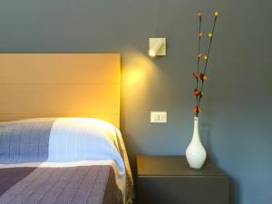 カステッランマーレ・デル・ゴルフォにあるCorso Ventinoveのベッドルーム1室(ベッド1台、テーブル上の花瓶付)