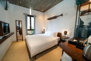 a bedroom with a white bed and a television at The Memory Danang Boutique in Da Nang