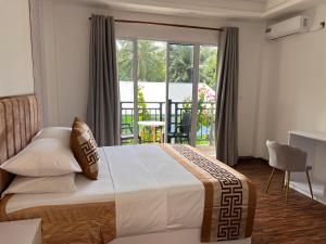 a bedroom with a large bed and a balcony at Alma Maldiva, Beach Hotel in Ariyaddu +121 photos