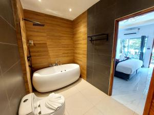 西塔努Samma Karuna Beach & Wellness Resort - Intoxicants free的带浴缸、马桶和水槽的浴室