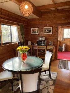 a dining room with a table with a vase of flowers on it at Forest View Guesthouse in Omachi