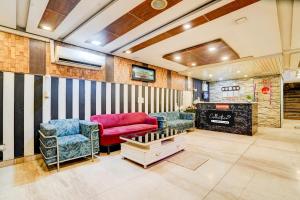 Collection O Kalka Ji Formerly Hotel Gera في نيودلهي: غرفة معيشة مع أريكة وكرسيين