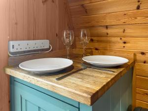 two white plates and wine glasses on a wooden counter at Birds - Uk48489 in Dalton in Furness