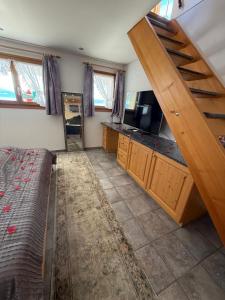 HinwilPanorama-Chalet Unterbach的一间带床和电视的房间以及楼梯 更多12张照片