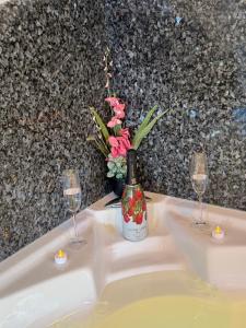 HinwilPanorama-Chalet Unterbach的一瓶葡萄酒放在水槽上，旁边还有两个酒杯。