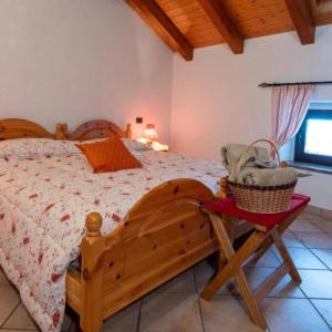 um quarto com uma cama de madeira e uma cesta sobre a mesa em Cjase Cumine em Lauco