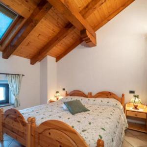 um quarto com uma cama de madeira e tectos de madeira em Cjase Cumine em Lauco