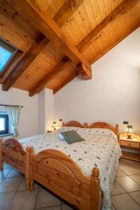 uma grande cama de madeira num quarto com tectos de madeira em Cjase Cumine em Lauco