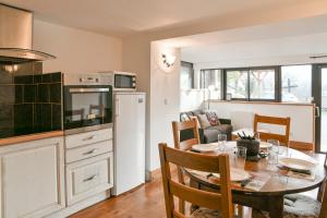 eine Küche und ein Esszimmer mit einem Tisch und einem Kühlschrank in der Unterkunft Le Chat De Lamartine - Clim Parking in Saint-Pierre-dʼAlbigny