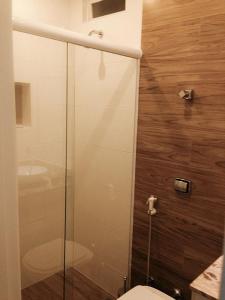 uma casa de banho com uma cabina de duche em vidro e um WC. em Studio Posto 6. no Rio de Janeiro