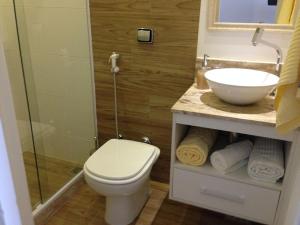 a bathroom with a toilet and a sink at Studio Posto 6. in Rio de Janeiro