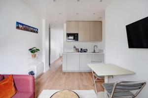 een woonkamer met een tafel en een keuken bij Comfortable and modern 2P studio - 16th Paris in Parijs +7 foto's