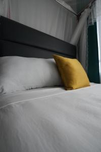 a yellow pillow sitting on top of a bed at Modern 1-Bedroom Apartment Near Kisumu CBD, Free WiFi, Parking & Security in Kisumu