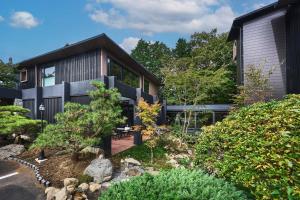 a black house with a garden in front of it at Hakone Hibarino hot spring hotel in Hakone
