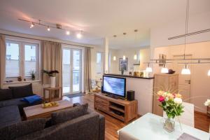 a living room with a couch and a television at Eicher Ferienwohnungen Warnemünde in Warnemünde