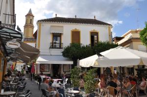 a group of people sitting at tables in front of a building at Casa de las Remigias in Estepona