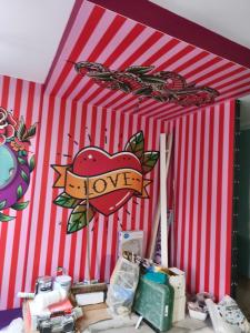 een rood-wit gestreepte tent met een bordje waarop 'liefde' staat bij Capsule Tattoo Love in Douai