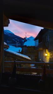 una persona che guarda fuori da una finestra il tramonto di CAV MES VALLEES La Thuile a La Thuile