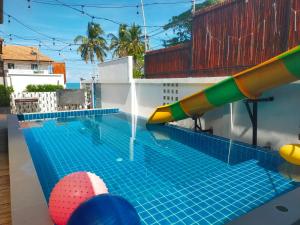 una piscina con uno scivolo d'acqua in cima a una casa di เดอะเบสท์ พูลวิลล่า ขนอม a Ban Tha Chan