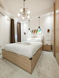 a bedroom with a large bed and a chandelier at Valley View 4 in Luqa