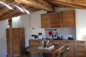 una cucina con mobili in legno e un tavolo in legno di CAV MES VALLEES La Thuile a La Thuile Altre 8 foto