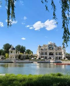 un grand bâtiment blanc à côté d'une étendue d'eau dans l'établissement Dequan Luxury HotelGuomao BranchThe subway is right outside the door Coffee, fruits, snacks, a gym and a laundry room are provided for free in the lobby, à Pékin