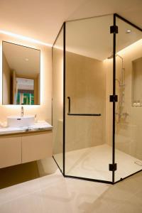 a bathroom with a glass shower and a sink at HAITA Suites - Phu My Hung in Ho Chi Minh City +36 photos