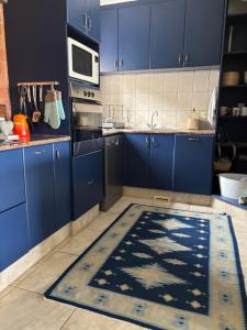 een keuken met blauwe kasten en een blauw kleed op de vloer bij Hakuna Matata Sedge in Sedgefield