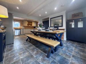 eine große Küche mit einem Holztisch und einer Bank in der Unterkunft Hill House - Uk49727 in Oxborough