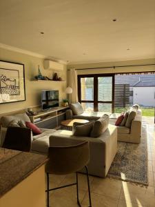 een woonkamer met 2 banken en een televisie bij Hakuna Matata Sedge in Sedgefield