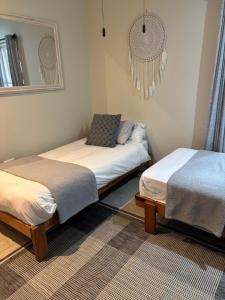 een kamer met 2 bedden en een spiegel bij Hakuna Matata Sedge in Sedgefield