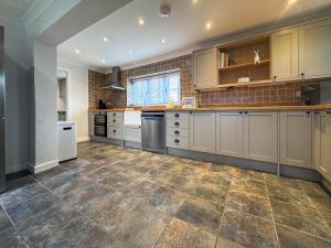 eine große Küche mit weißen Schränken und Fliesenboden in der Unterkunft Hill House - Uk49727 in Oxborough + 16 Fotos