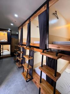 CogonKugi Hostel - Self Check-in Capsule Hostel near Cebu Airport的一间设有一排双层床的房间