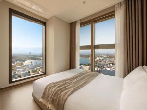 Postel nebo postele na pokoji v ubytování 플라트 더 원 속초자이엘라 더 비치