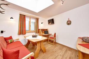 a living room with a couch and a table at Landhaus Bergliebe in Mittenwald