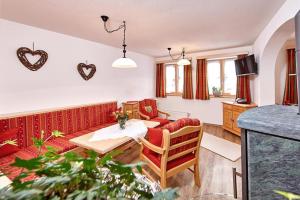 a living room with a couch and a table at Landhaus Bergliebe in Mittenwald
