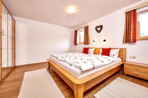 a bedroom with a large bed with red pillows at Landhaus Bergliebe in Mittenwald